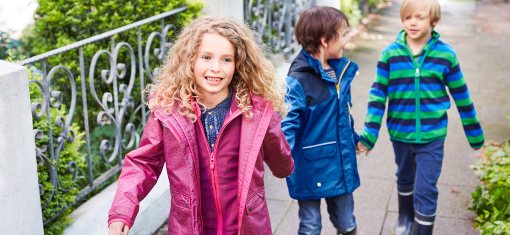 Kinder mit Regenjacke und Gummistiefel