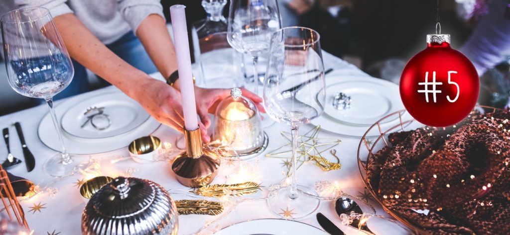 Weihnachtlich dekorierte Tafel mit Kerzen, Lämpchen und goldigen Sternen.