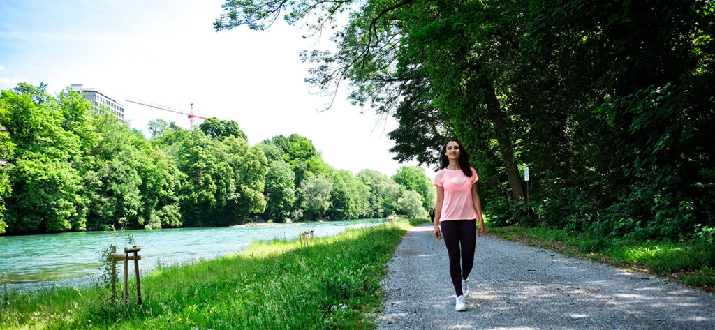 Fitnessexpertin Roxy beim Spazieren im Freien am Fluss entlang.